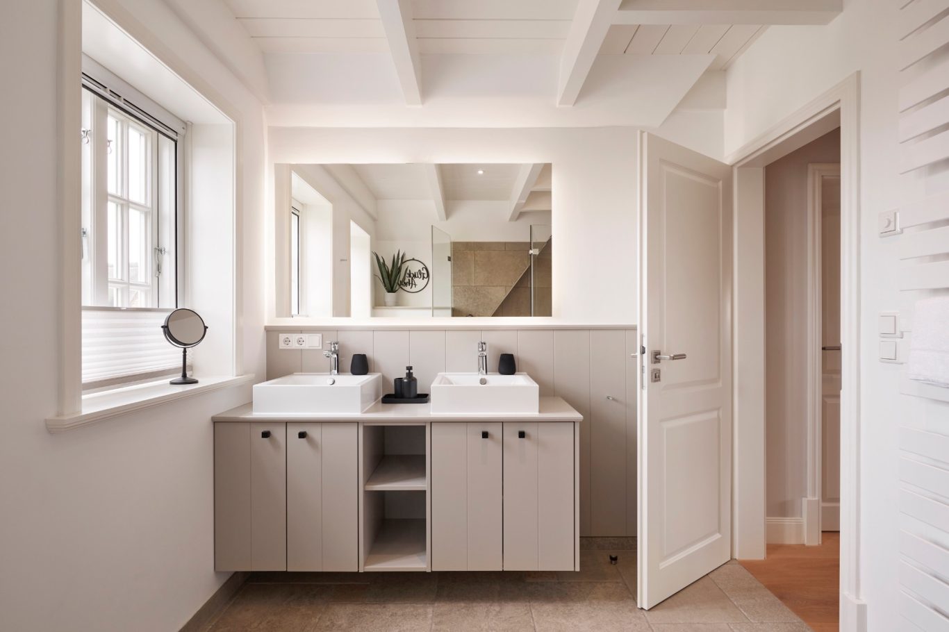 Modernes Badezimmer mit doppeltem Waschbecken und großem Spiegel. Helle, einladende Atmosphäre.